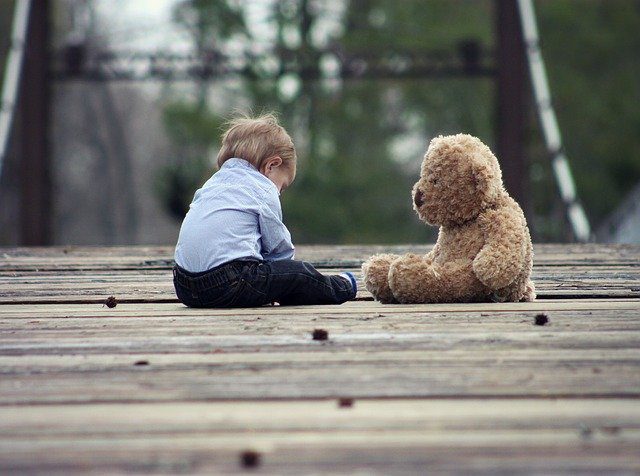 seated toddler with a teddy bear